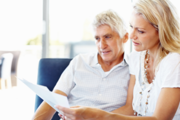 Adult child and older McKinney homeowner reviewing home documents before a future real estate decision